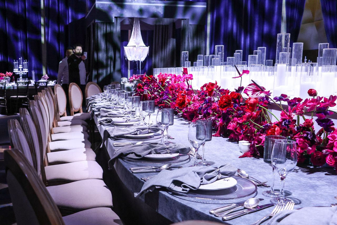 A luxurious table setting with vibrant floral decorations and elegant tableware, perfect for upscale events.